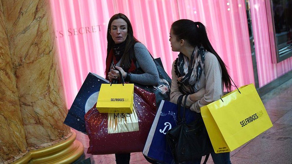 Shoppers carry bundles of shopping bags in Manchester