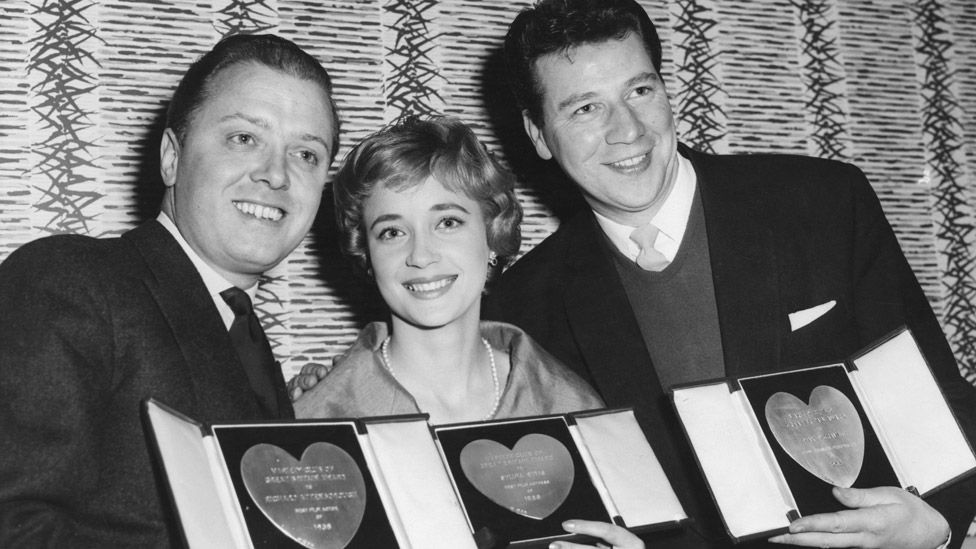 Слева направо: Ричард Аттенборо, Сильвия Симс и Макс Байгрейвс со своими наградами на ежегодном обеде в честь вручения наград шоу-бизнеса Variety Club в отеле Savoy в Лондоне, 10 марта 1959 года