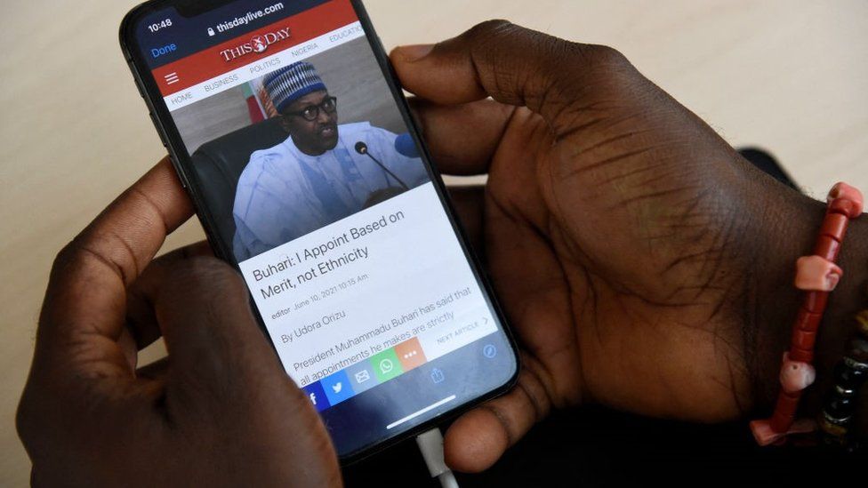 Журналист получает информацию со смартфона в Интернете в Arise News в районе Икойи в Лагосе, 10 июня 2021 г.