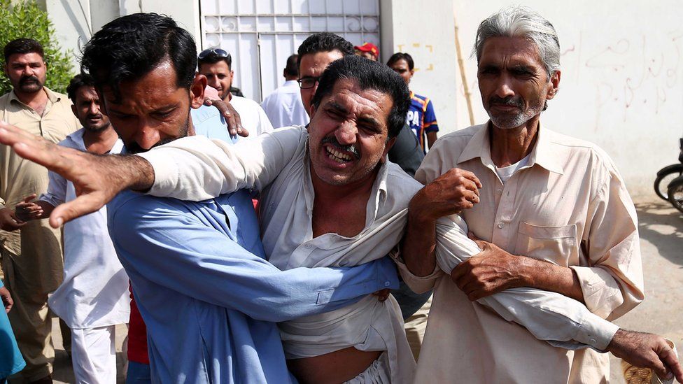 People console an unidentified relative of one of the victims of the attack on Chinese consulate
