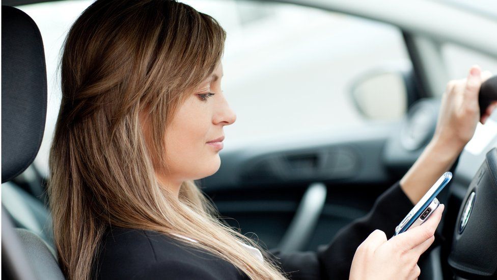 Woman using a mobile phone in the car