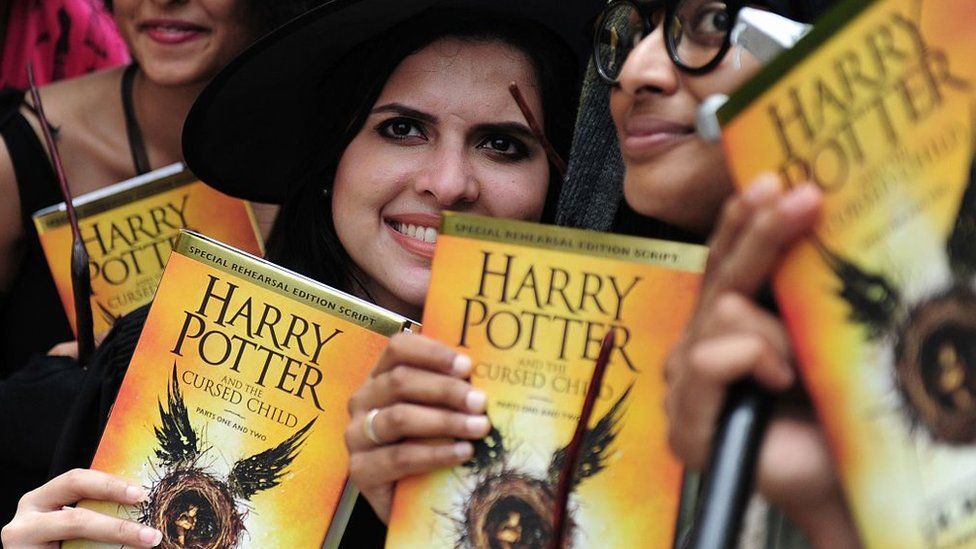 People holding Harry Potter books