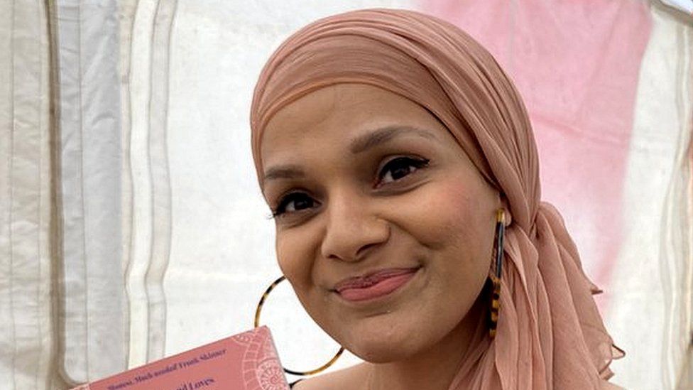 Muslim woman in headscarf holds a copy of her book "Sex Bomb"