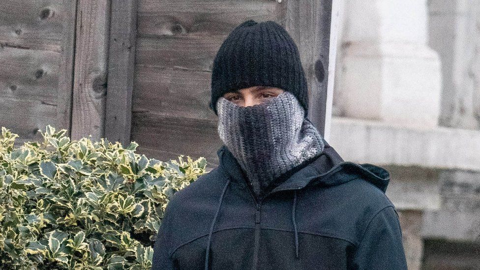 Photo of PC Hussain Chehab wearing a hat and a scarf pulled up over his mouth and nose.