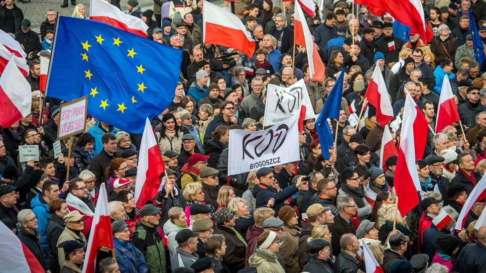 People waving flags and holding placards attend a demonstration at the Old Market in Bydgoszcz, Poland, 19 December 2015.