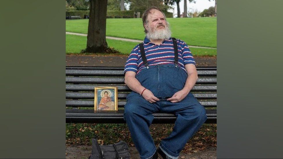 Portrait of man sat on bench