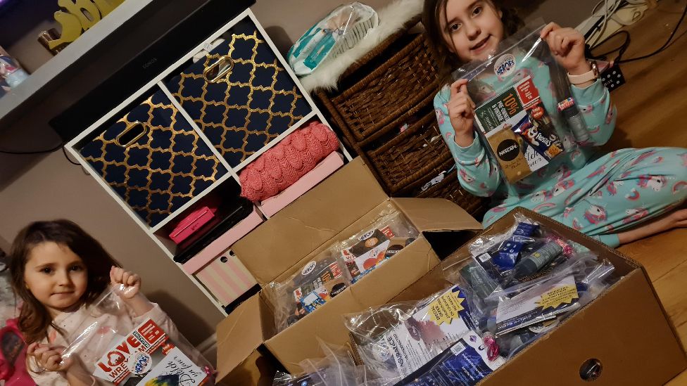 Two children helping to prepare the Hugs for Heroes goody bags