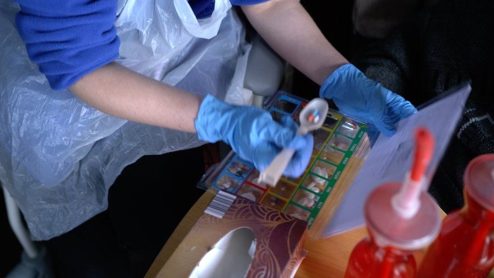Close-up of care worker's hands with medication on a spoon