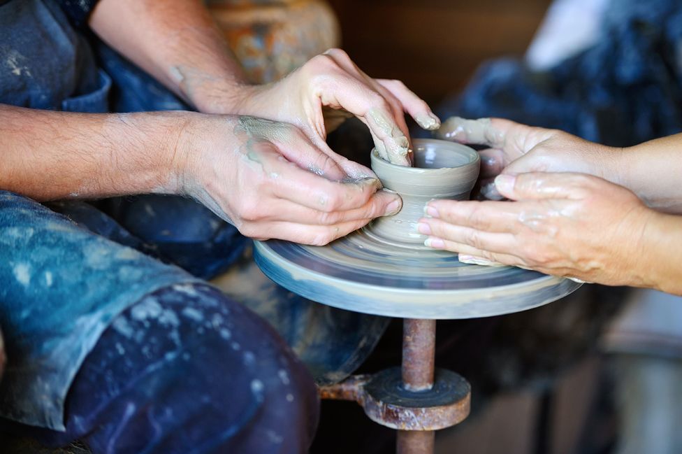 Two people at a potter's wheel