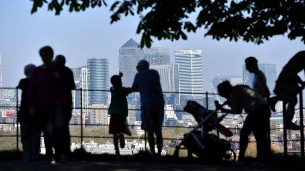People look at Canary Wharf in London