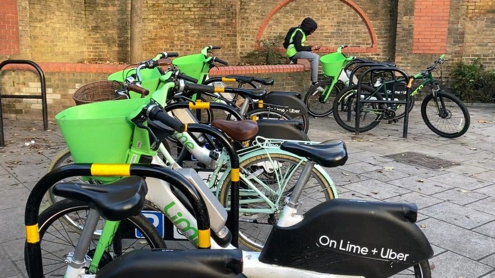 Rows of lime bikes parked in bike racks outside Wandsworth Town station