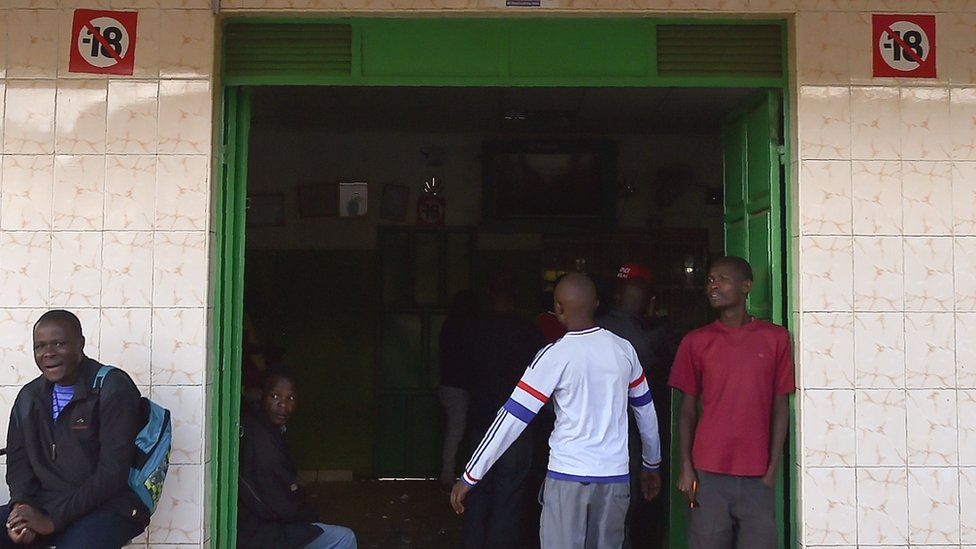 Мужчина заходит в популярный центр ставок на спорт в пригороде Найроби Кавангваре, ноябрь 2017 г.