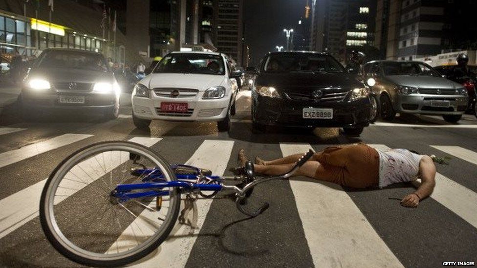 A cyclist lies on the ground on Avenida Paulista during a demonstration in Sao Paulo on 6 March, 2012
