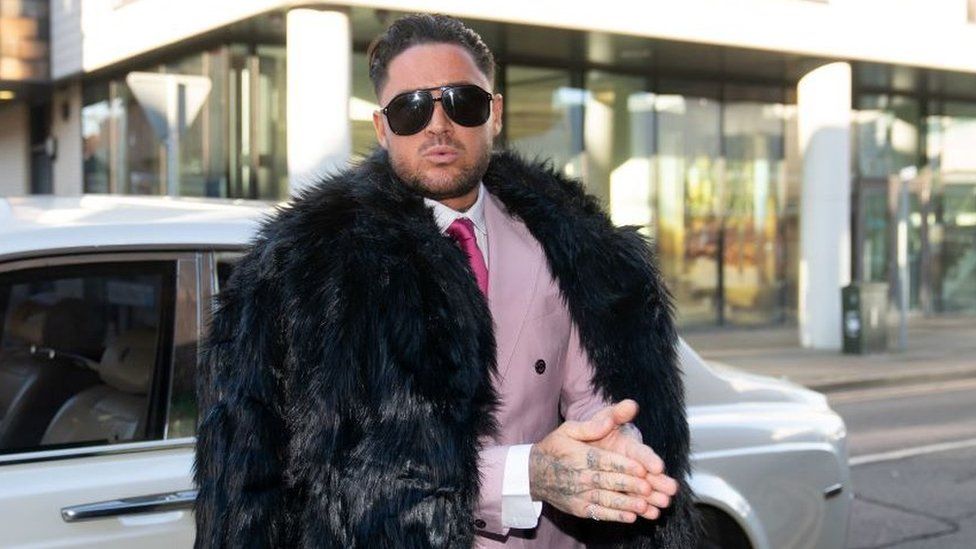 Stephen Bear dressed in a pink suit and tie with black fur coat outside Chelmsford Crown Court