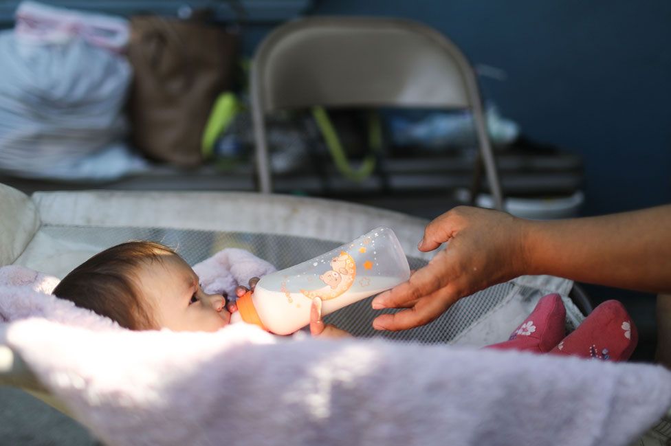 A migrant mother feeds her daughter in a shelter in Tijuana, Mexico