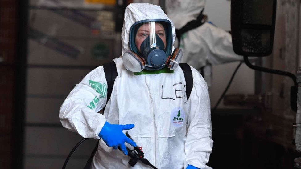 A cleaner in full protective equipment outside an infection site in Sydney