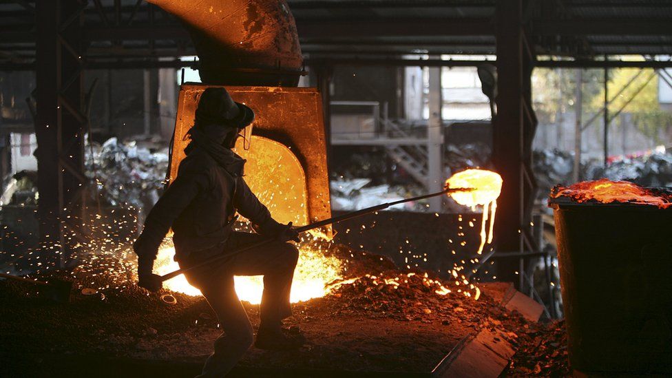 A labourer works inside a steel factory on the outskirts of Jammu, India