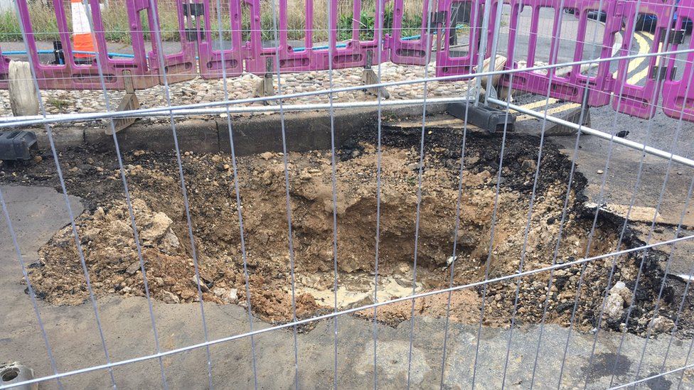 Hole in road caused by burst water main