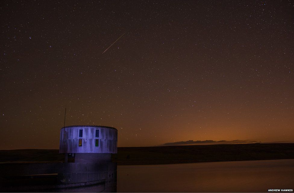 A Perseid meteor photographed over a reservoir