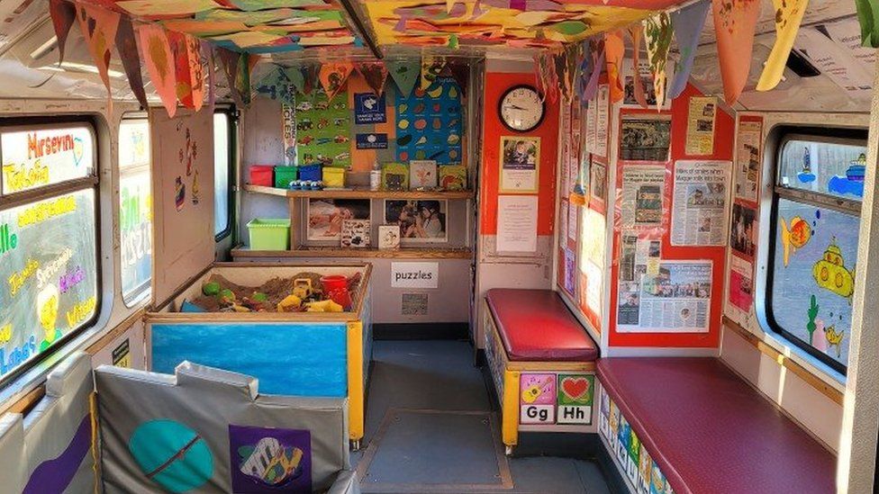 The inside of the Ipswich Community Playbus, complete with sandpit, puzzles and paintings