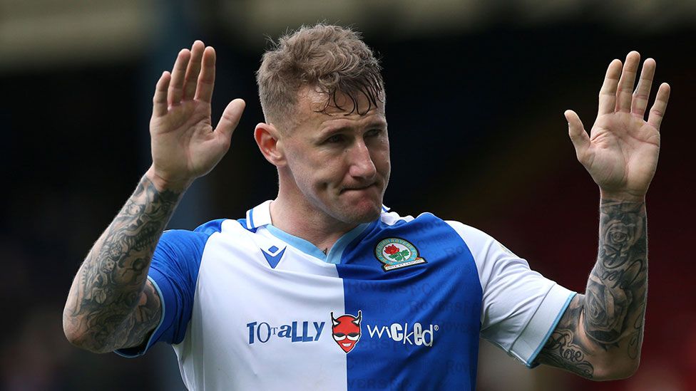 A Blackburn Rovers player holds his hands up, with the Totally Wicked vape brand visible on his shirt