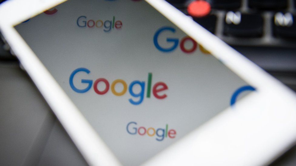 Google logo reflected in a phone screen