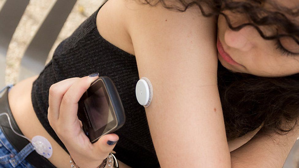 A woman using the flash glucose monitoring system