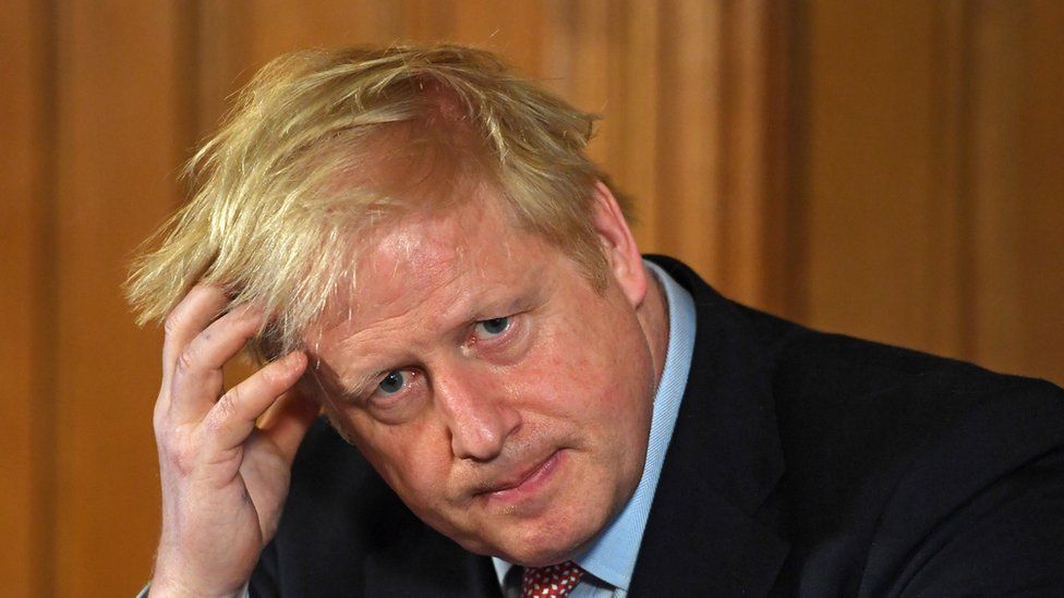 Prime Minister Boris Johnson places his hand on his head as he is deep in thought at a news conference inside No 10 Downing Street, London
