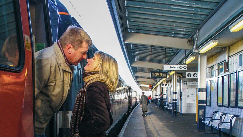 Couple kissing on a railway station