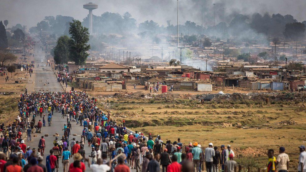 A mob armed with spears, batons and axes run through Johannesburg's Katlehong Township during a new wave of anti-foreigner violence on 5 September