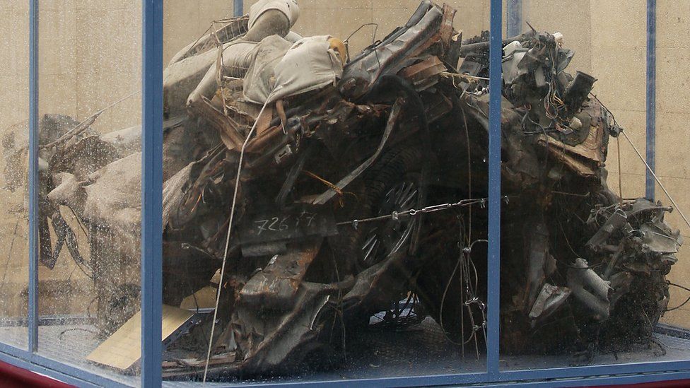 Italian President Giorgio Napolitano looks at the remains of a police car destroyed during of the assassination of top judge Giovanni Falcone during a ceremony marking the 20th anniversary of the event on May 23, 2012 in Palermo, Italy