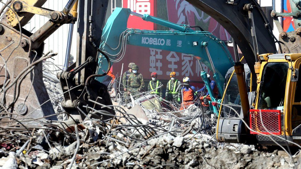 Heavy machines clear up the remains of a collapsed 17-storey building in Tainan City, south Taiwan, 13 February 2016.