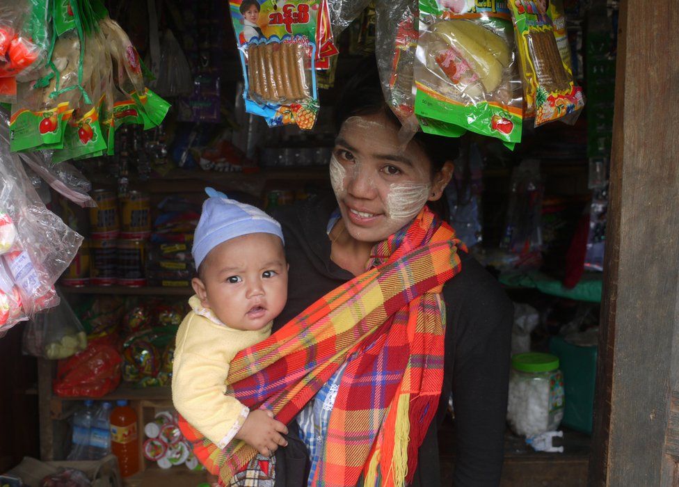 A woman and her baby in a small store in Myanmar