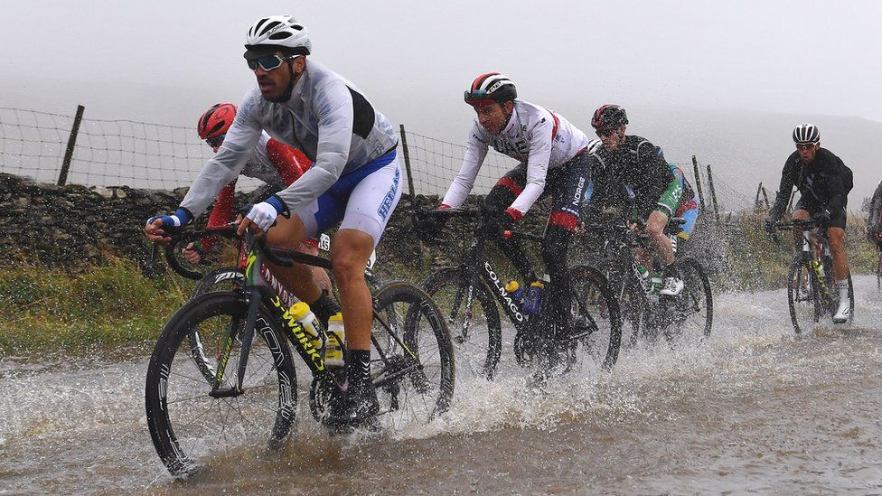 Cyclists ride through flooded race route on Cray Summit