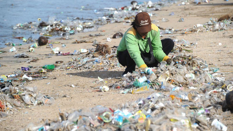 Person collecting rubbish at Kuta beach