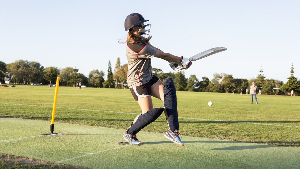 A girl batting in cricket, hitting the ball to her left hand side