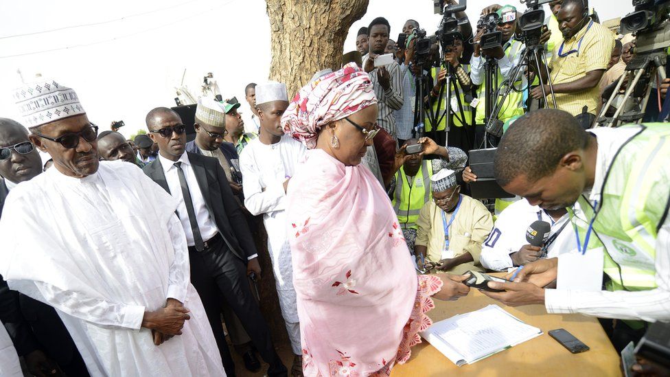 Aisha Buhari registers to vote as the president looks on