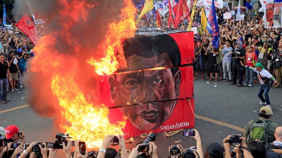 Effigy of Duterte is burned outside the presidential palace in Manila