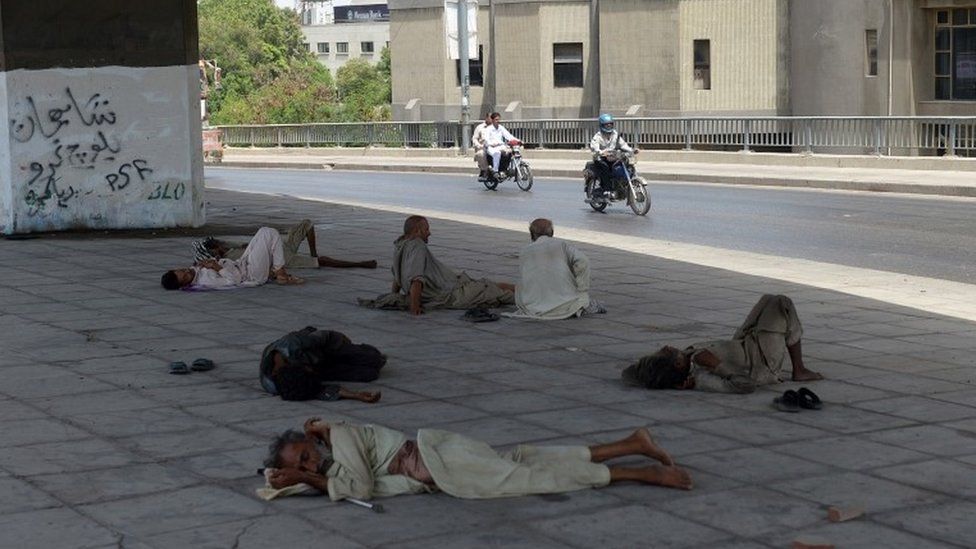 Pakistani men rest under a bridge during a heatwave in Karachi on June 29, 2015.