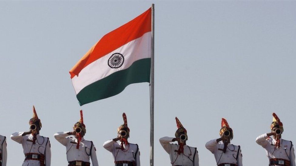Indian Border Security Force (BSF) soldiers perform beneath an Indian flag during a passing out parade ceremony in Humhama, on the outskirts of Srinagar, India, Thursday, Oct. 11, 2012.