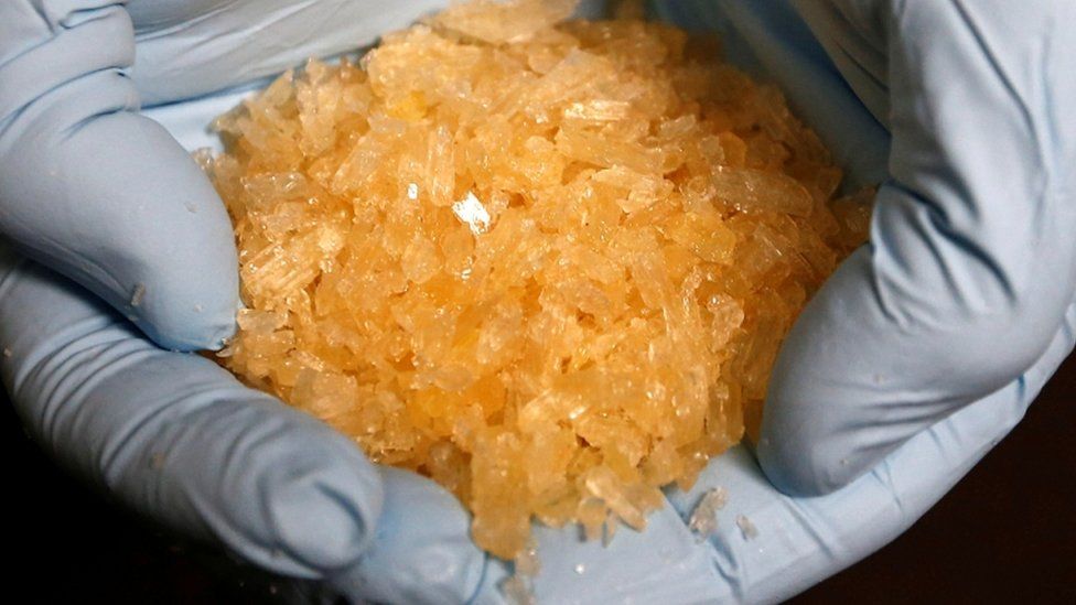 Crystal Methamphetamine (crystal meth) pictured in a person's gloved hands