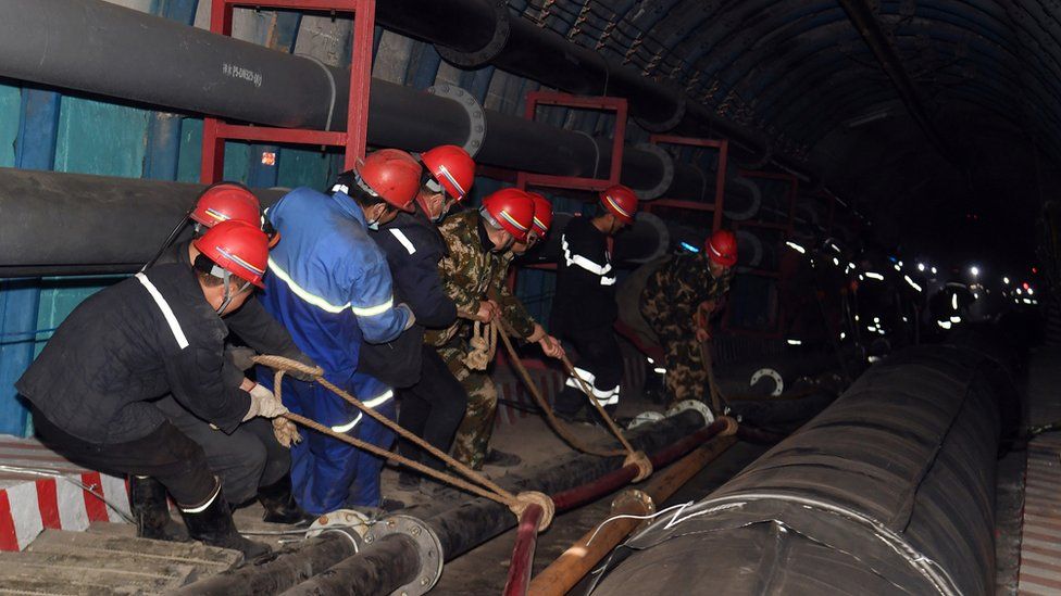 Rescuers work at the site where a coal mine flooded in Hutubi county