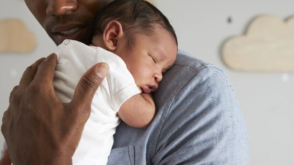 A father holding a newborn baby