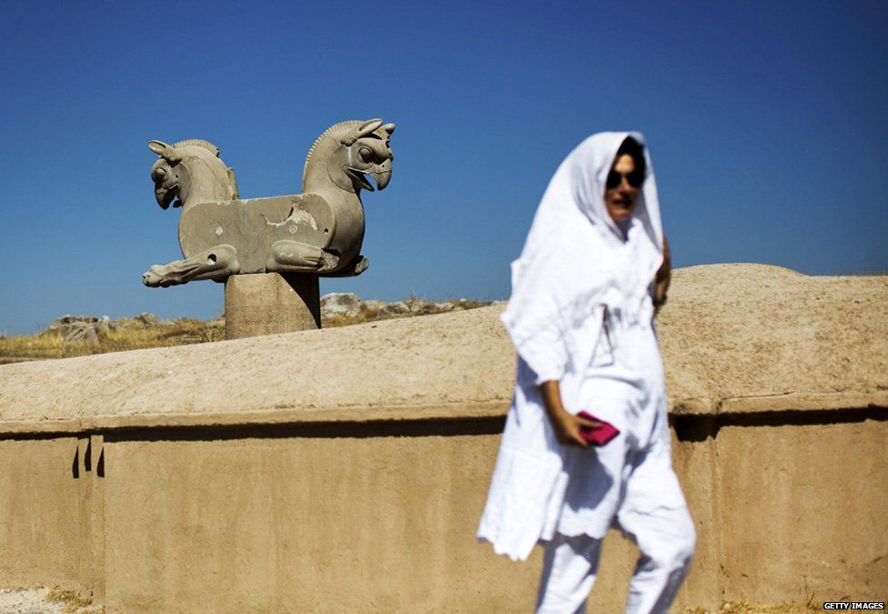 A Spanish tourist walks past an Achaemenid griffin at the ancient Persian city of Persepolis