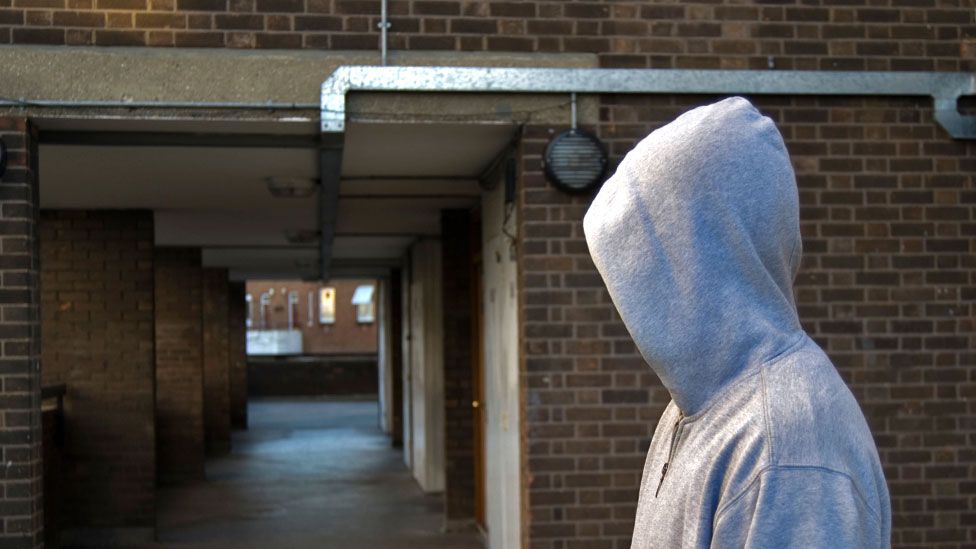 Man in grey hoodie in block of flats