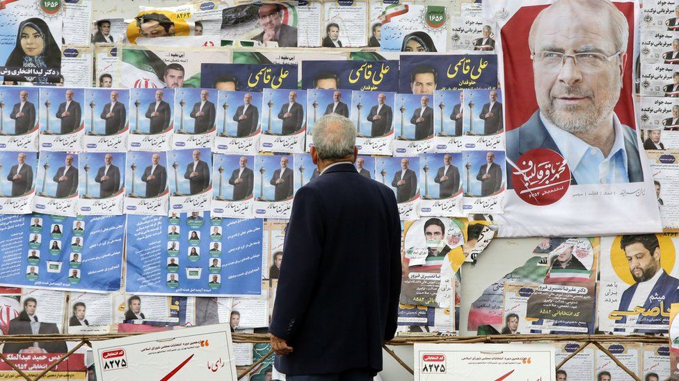 A man looks at electoral posters on a wall in Tehran, Iran (28 February 2024)