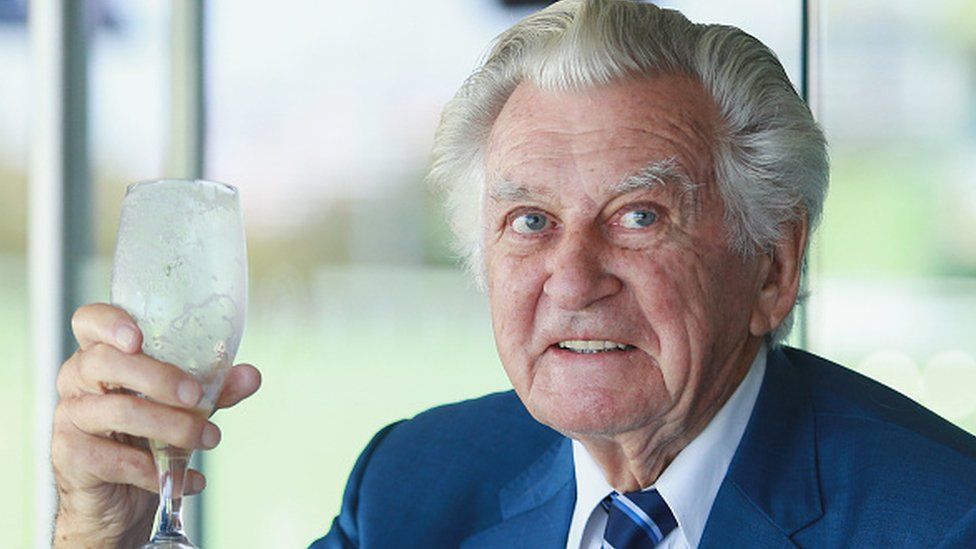Bob Hawke holds a glass of beer