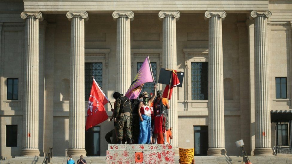 Протестующие стоят на пьедестале, на котором когда-то стояла статуя королевы Виктории