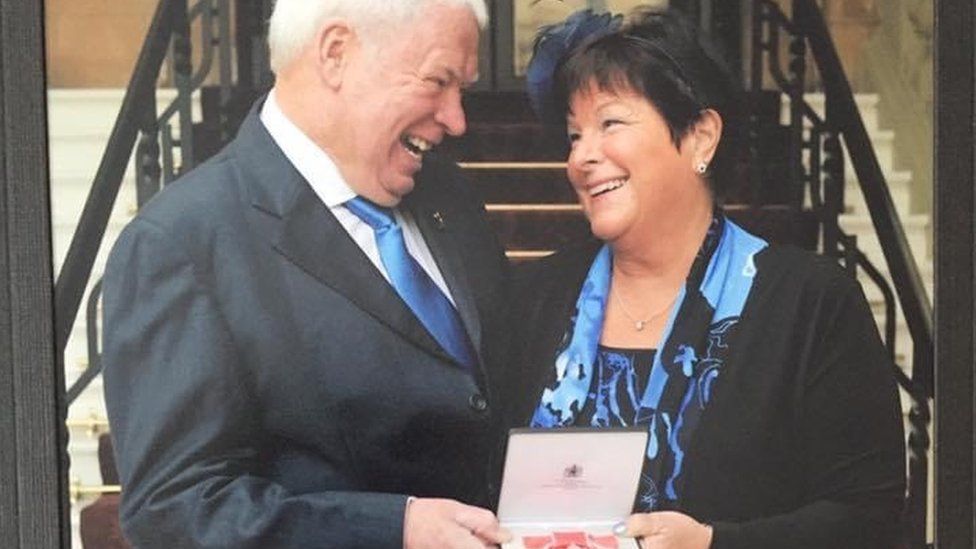 Sally Minty-Gravett and husband Charlie collecting her MBE