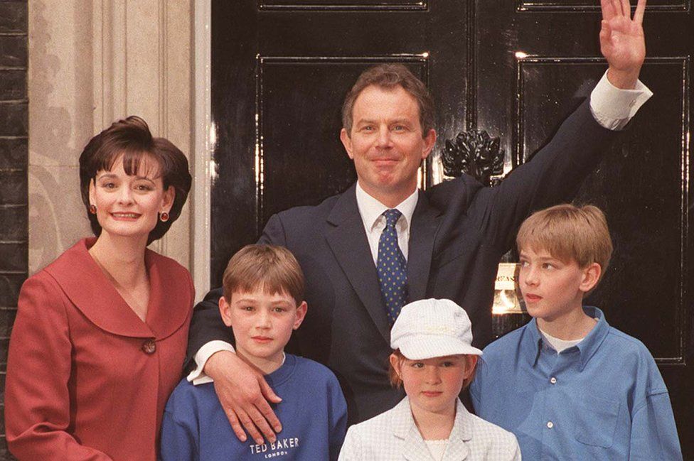 Prime Minister Tony Blair waving to the crowd with his wife Cherie and their children